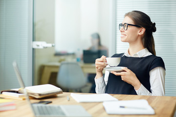 Sticker - Young female with cup of tea having break by her workplace in office