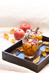 Hot spicy drink,tea with fruits and berrie on dark wooden tray. Autumn style photo.