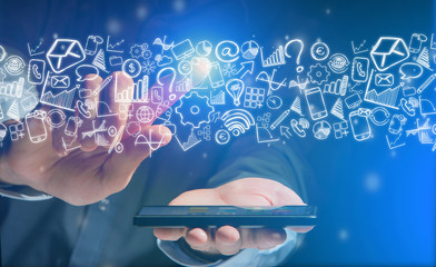 Hand of a man holding device with internet icons all around
