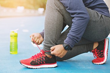 Wall Mural - male hands tying shoelace on running shoes before practice. Runner getting ready for training. Sport active lifestyle concept. 