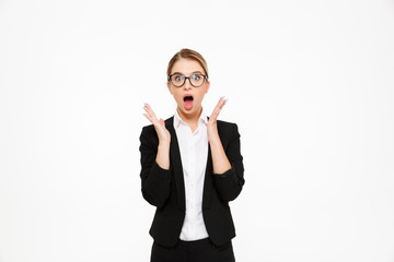 Wall Mural - Shocked blonde business woman in eyeglasses holding hands near head