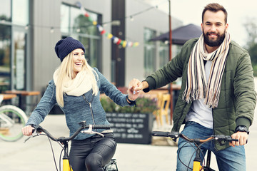 Wall Mural - Young couple riding bikes and having fun in the city