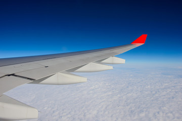 Wall Mural - Wing of airplane in the sky red winglet blue sky