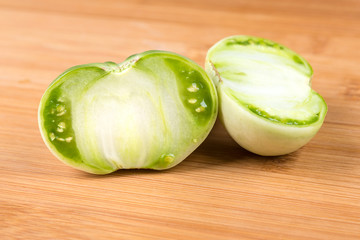 Fresh sliced green tomatoes on a wood background