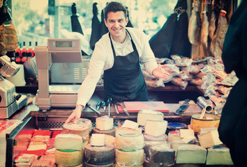 Wall Mural - Male seller offering assortment of cheese