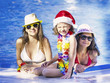 © kravik93 - Happy girls and baby sitting near the pool during Christmas
