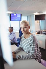 Wall Mural - Thoughtful businesswoman sitting on exercise ball at desk