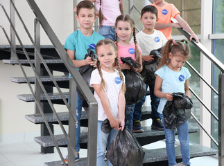 Canvas Print - Happy volunteers and children with garbage bags standing on stairs