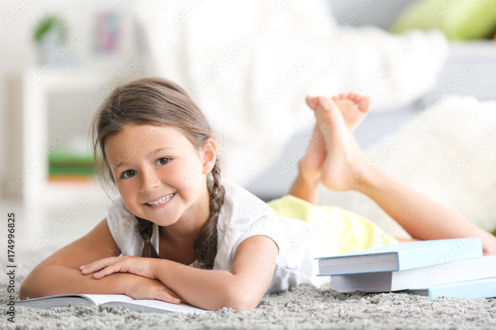 Cute little girl reading book at home