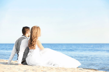 Wall Mural - Happy wedding couple on sea beach