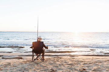 Wall Mural - Senior man fishing at sea side