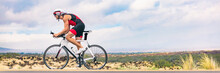 Triathlon Biking Man Cycling On Road Bike In Nature Background Banner. Cyclist Triathlete Riding Bicycle In Ironman Competition. Panorama Header Crop For Landscape Copy Space.