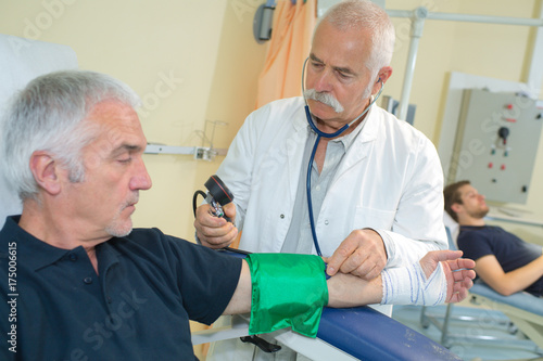 Plakat lekarz pomiaru ciśnienia krwi pacjenta starszych