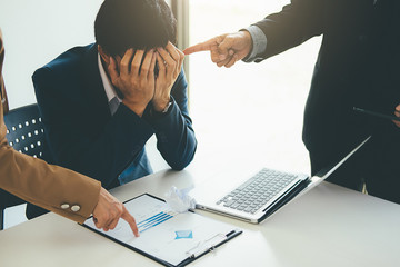 Wall Mural - Angry boss giving a document to a sad employee sitting in a desk at office