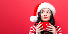 Happy Young Woman With Santa Hat Drinking Coffee