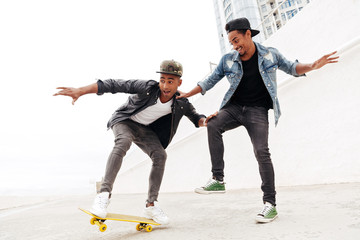 Wall Mural - Happy two young african men friends walking