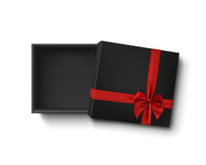 Opened black empty gift box with red ribbon and bow.