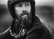 © Mint Images - Portrait of bearded man wearing open face crash helmet, goggles round his neck.