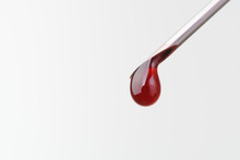 Drop Of Blood Falling From Syringe On White Background, Macro Shot