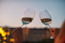 Hands With Glasses Of White Wine Checking Wine Quality At Sunset Light