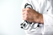 © pantovich - Close up of professional male doctor in white gown with stethoscope in hand