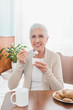 © LIGHTFIELD STUDIOS - senior woman eating yogurt