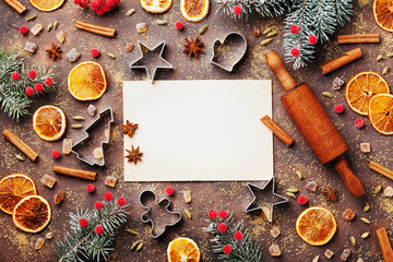 Wall Mural - Holiday food background for baking gingerbread cookies with cutters, rolling pin and spices on table top view. Vintage paper sheet for christmas recipe.