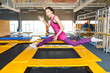 © EdNurg - Cheerful and happy woman practicing and jumping on trampolines in a sports indoor center, workout and modern entertainment concept