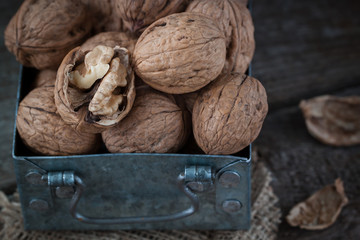 Walnuts in a small iron box and a canvas napkin.