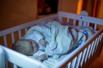 Canvas Print - Adorable newborn baby boy, sleeping in crib at night