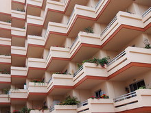 Pink Balconies On Large Modern Apartment Building With House Plants