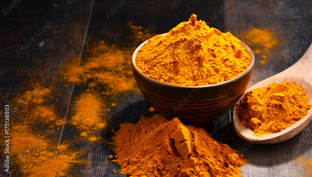 Composition with bowl of turmeric powder on wooden table - obrazy, fototapety, plakaty 