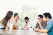 © Urbanscape - Diverse group of five Asian business person in team meeting at coffee shop or modern office. Strategic brainstorm, small business owner, Family talk, information technology or social lifestyle concept