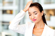 © Nobilior - Woman with a headache in an office. Woman forgot something.