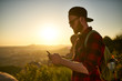 © Joshua Resnick - bearded millennial hiker using smartphone during hike