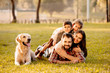 © LIGHTFIELD STUDIOS - family lying in pile on grass