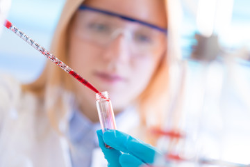 Canvas Print - Female laboratory assistant with chemical experiment in scientific laboratory