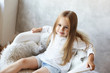 © shurkin_son - Indoor shot of charming blue eyed Caucasian little girl wearing her long straight hair loose sitting in relaxed posture on armachair at home and listening to her mother with attentive positive smile