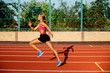 © nazarovsergey - Side view beautiful young woman exercise jogging and running on athletic track on stadium