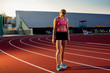 © nazarovsergey - Picture of beautiful young European female runner or sprinter standing on outdoor stadium track, feeling exhausted after sprint or marathon.