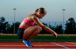 © nazarovsergey - Picture of beautiful young European female runner or sprinter sitting on outdoor stadium track, feeling exhausted after sprint or marathon.