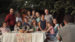 © Framestock - Cheerful family standing at table in garden and posing for photo.