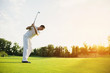 © VadimGuzhva - A man in a white suit plays golf. He took the stick and was preparing to strike