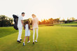 © VadimGuzhva - A man, a girl and a woman are walking along the golf course towards the sunset, holding hands
