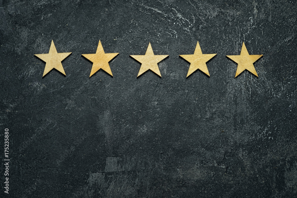 Five stars in a row on a black rustic cement boards. Conceptual of service rating and quality of trade. Top view, copy space for your text. - obrazy, fototapety, plakaty 