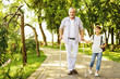 © VadimGuzhva - A boy and an old man on crutches are walking in the park. The boy is holding the old man's hand
