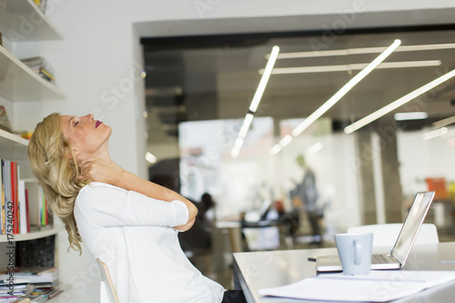 Zdjęcie XXL Bizneswoman w biurze bierze przerwę i robi szyi ćwiczeniu