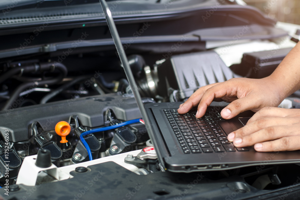 Detail of a mechanic using electrnoic diagnostic equipment to tune a car - obrazy, fototapety, plakaty 