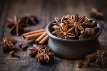 Anise Stars In A Black Bowl With Cinnamon Sticks And Cloves. Winter Seasonal Baking Concept With Copy Space For Your Text