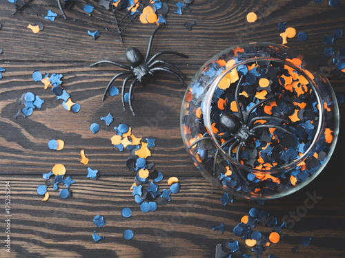 Zdjęcie XXL Halloweenowi pomarańczowi i czarni confetti z pająkami i pająkiem zarabiają netto na ciemnym nieociosanym drewnianym tle. Symbole dekoracji wakacje